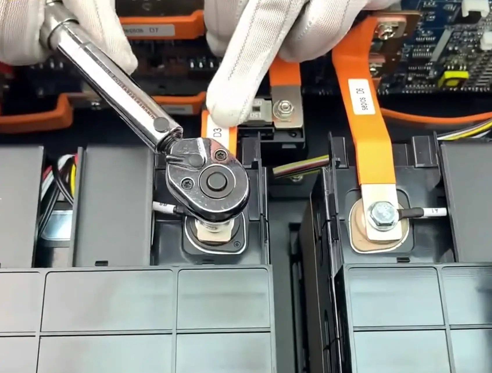 Technician using a wrench on lithium battery terminals in solar energy storage system for camper vans boats ensuring efficient power management and safety.
